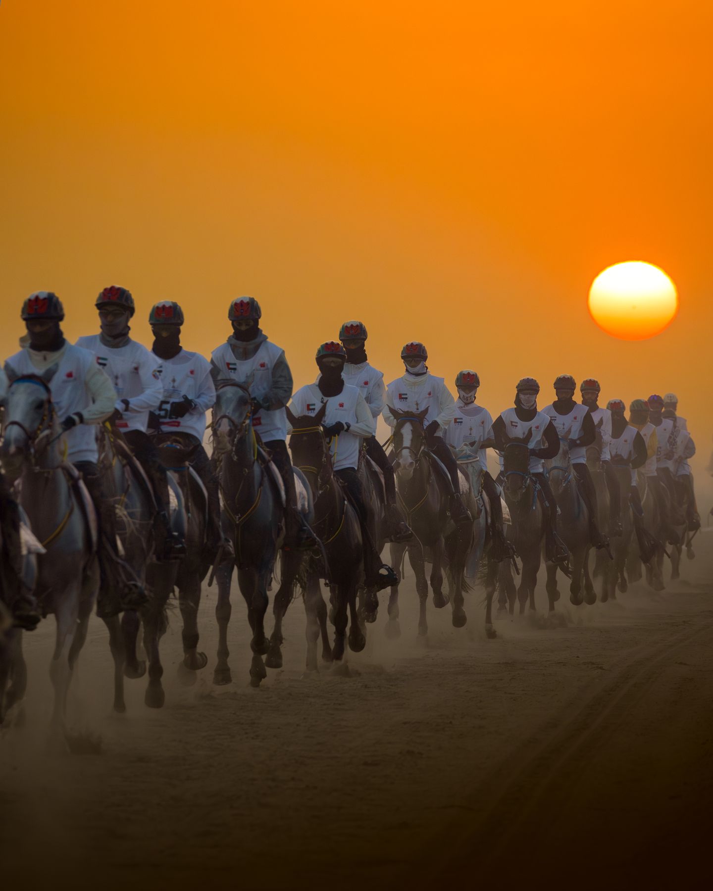 A group of riders at sunrise on the desert course